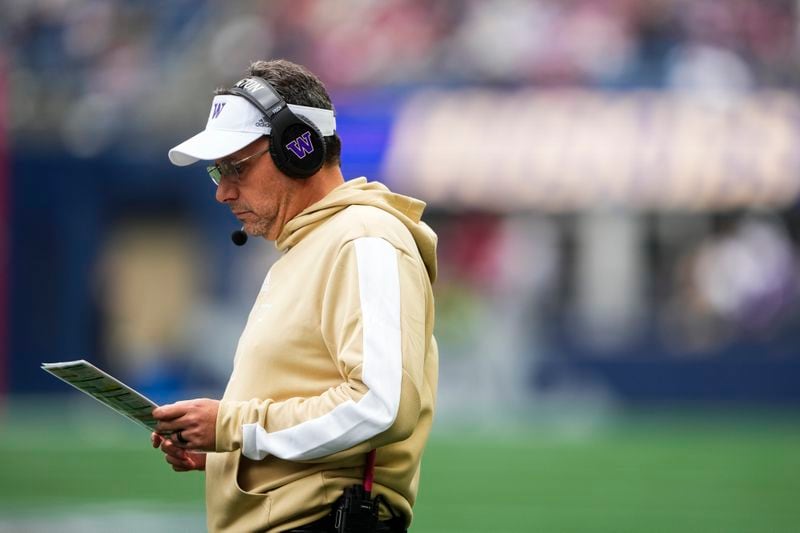 Washington head coach Jedd Fisch looks down at a play sheet during the first half of an NCAA college football game against Washington State, Saturday, Sept. 14, 2024, in Seattle. (AP Photo/Lindsey Wasson)