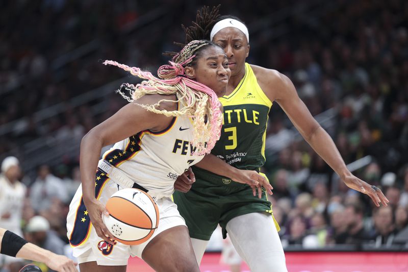 Indiana Fever forward Aliyah Boston drives as Seattle Storm forward Nneka Ogwumike defends during the second half of a WNBA basketball game Wednesday, May 22, 2024, in Seattle. The Storm won 85-83. (AP Photo/Jason Redmond)