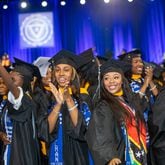 Alexis White, claps with Ariana Williams as they acknowledge their families during Spelman College’s 137th commencement at the Georgia International Convention Center on Sunday, May 19, 2024. Angela Bassett, the keynote speaker, and Supreme Court Justice Ketanji Brown Jackson were both awarded honorary degrees.  (Jenni Girtman for The Atlanta Journal-Constitution)