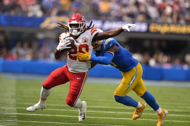 Kansas City Chiefs running back Kareem Hunt (29) runs with the ball as Los Angeles Chargers linebacker Daiyan Henley defends during the second half of an NFL football game Sunday, Sept. 29, 2024, in Inglewood, Calif. (AP Photo/Marcio Jose Sanchez)