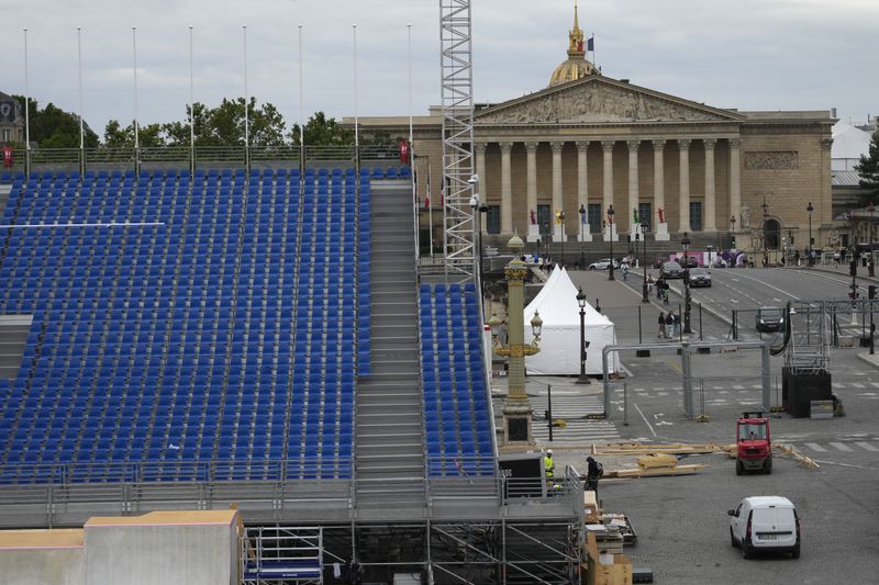 Construction work is seen at the Concorde Olympic venue and the National Assembly, right, on Wednesday, July 3, 2024 in Paris. Just three weeks before the Olympics, the excitement that was building up in the host city has mingled with anxiety about France’s political future. (AP Photo/Thibault Camus)