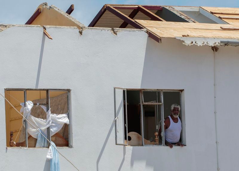 A man looks out of the window of his home, which was destroyed by Hurricane Beryl in Clifton, Union Island, St. Vincent and the Grenadines, Thursday, July 4, 2024. (AP Photo/Lucanus Ollivierre)