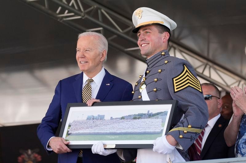 A graduating cadet, right, presents a class gift to President Joe Biden at the U.S. Military Academy commencement ceremony, Saturday, May 25, 2024, in West Point, N.Y. (AP Photo/Alex Brandon)