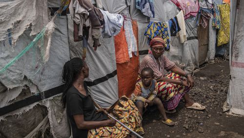 People sit at the Don Bosco refugee camp as Red Cross officials create awareness around mpox in Goma, Democratic Republic of Congo, Thursday, Aug. 22, 2023. (AP Photo/Moses Sawasawa)