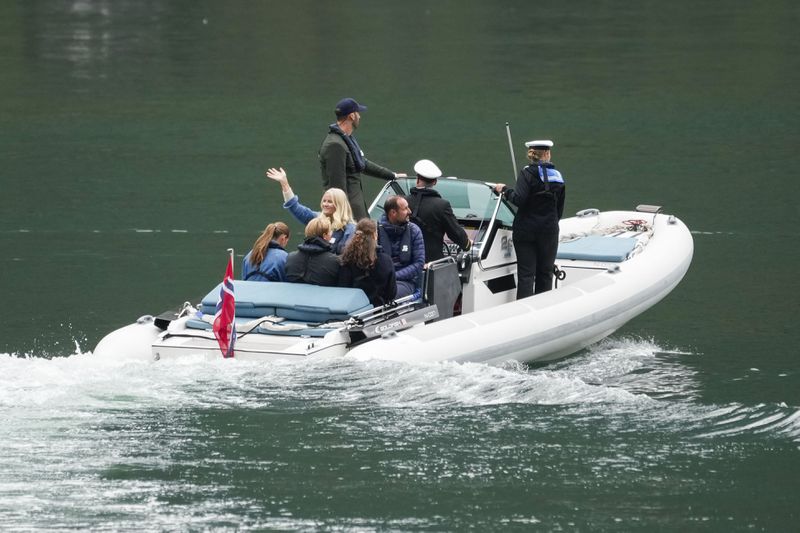 Norway's Crown Prince Haakon, 3rd right, Crown Princess Mette-Marit, center left waving, Princess Ingrid Alexandra, left, Prince Sverre Magnus, 2nd left, and Amalie Giaever MacLeod travel to Geiranger, Norway, Friday Aug. 30, 2024, ahead of the wedding celebration of Princess Martha Louise and Durek Verret on Saturday. (Cornelius Poppe/NTB via AP)