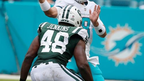 Miami Dolphins quarterback Matt Moore (8) throws under pressure from New York Jets outside linebacker Jordan Jenkins (48), during the first half of an NFL football game, Sunday, Oct. 22, 2017, in Miami Gardens, Fla. (AP Photo/Wilfredo Lee)