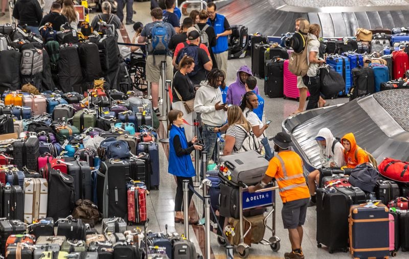 Luggage stored in the Delta Air Lines baggage claim area wait for passengers to claim them on Tuesday, July 23, 2024, at Hartsfield-Jackson International Airport amid a global meltdown of Delta's operations. Travelers have been sleeping at the Atlanta airport since the meltdown began Friday, July 19, 2024, with a technology outage that affected Microsoft users around the world.  (John Spink/AJC)