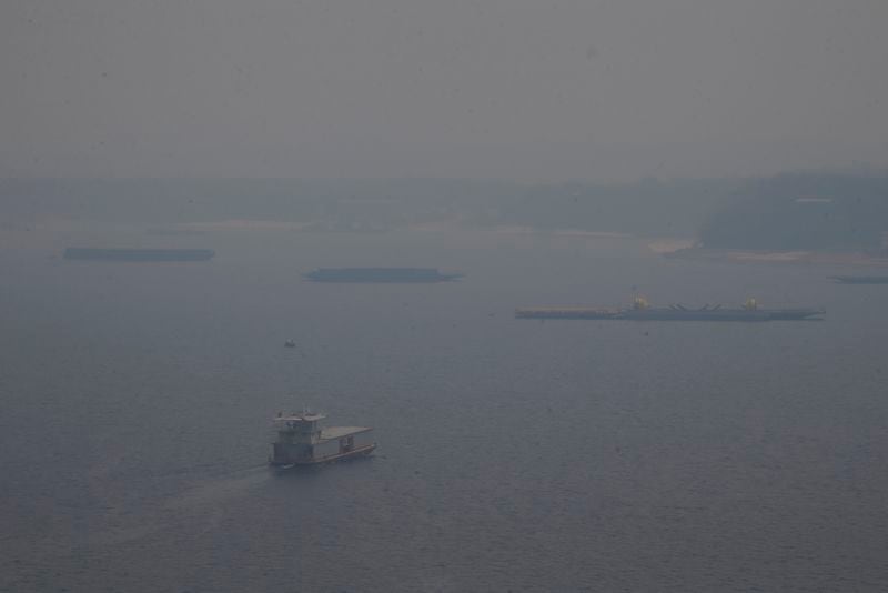 A boat navigates the Negro River amid smoke from wildfires in Manaus, Amazonas state, Brazil, Tuesday, Aug. 27, 2024. (AP Photo/Edmar Barros)