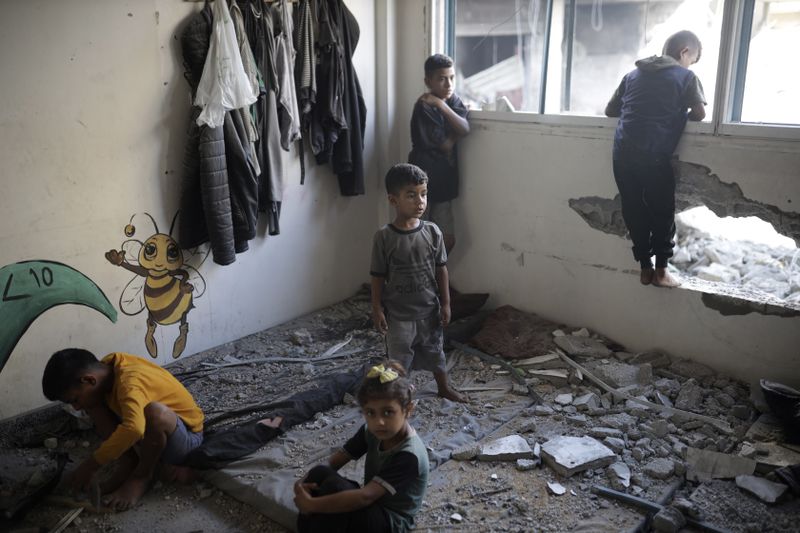 Palestinian children inspect heavy damage to a UNRWA school sheltering displaced persons the day after a nearby house was targeted by Israeli bombardment in Khan Younis, southern Gaza Strip, Friday, June 21, 2024. (AP Photo /Jehad Alshrafi)