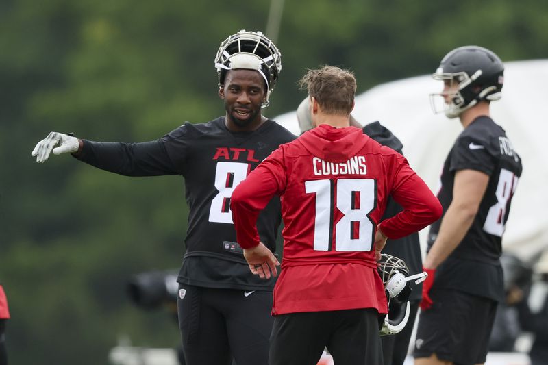 Atlanta Falcons quarterback Kirk Cousins (18) talks with tight end Kyle Pitts (8) during minicamp at the Atlanta Falcons Training Camp, Tuesday, May 14, 2024, in Flowery Branch, Ga. (Jason Getz / AJC)
