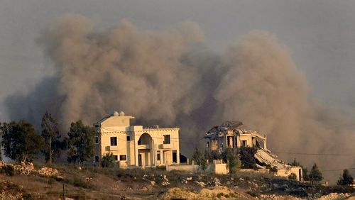 Smoke rises behind a destroyed house following an Israeli airstrike on Khiam village, as seen from Marjayoun town, south Lebanon, Tuesday, Sept. 24, 2024. (AP Photo/Hussein Malla)