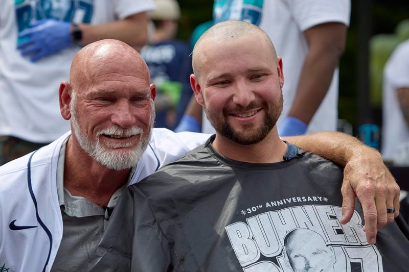 Seattle Mariners catcher Cal Raleigh, right, poses with former Mariners player Jay Buhner on Buhner Buzz Night, Thursday, June 13, 2024, in Seattle. The promotion is based on Buhner's shaved-head style. (AP Photo/John Froschauer)
