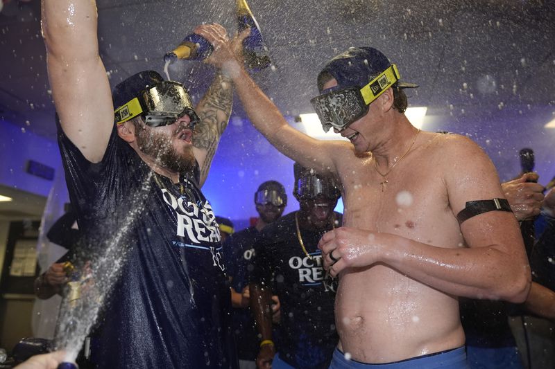 Kansas City Royals outfielder Kyle Isbel, left, and pitcher Brady Singer celebrate with teammates after defeating the Baltimore Orioles 2-1 in Game 2 of an AL Wild Card Series baseball game, Wednesday, Oct. 2, 2024 in Baltimore. (AP Photo/Stephanie Scarbrough)