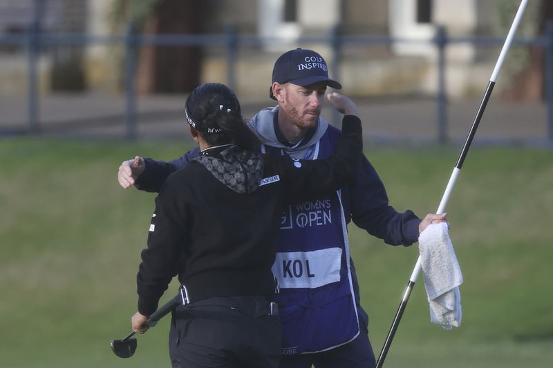 Lydia Ko, of New Zealand, hugs her caddie Paul Cormack after completing her round on the 18th green during the final round of the Women's British Open golf championship, in St. Andrews, Scotland, Sunday, Aug. 25, 2024. (AP Photo/Scott Heppell)