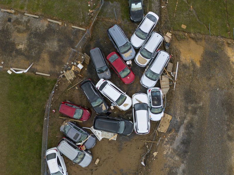 Vehicles and debris that were caught in a flash flood from Hurricane Helene rest on the side of the road near the Swannanoa River, Tuesday, Oct. 1, 2024, in Swannanoa, N.C. (AP Photo/Mike Stewart)