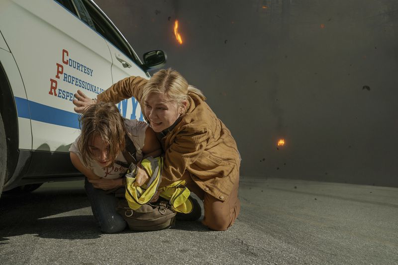 This image released by A24 shows Cailee Spaeny, left, and Kirsten Dunst in a scene from "Civil War." (A24 via AP)