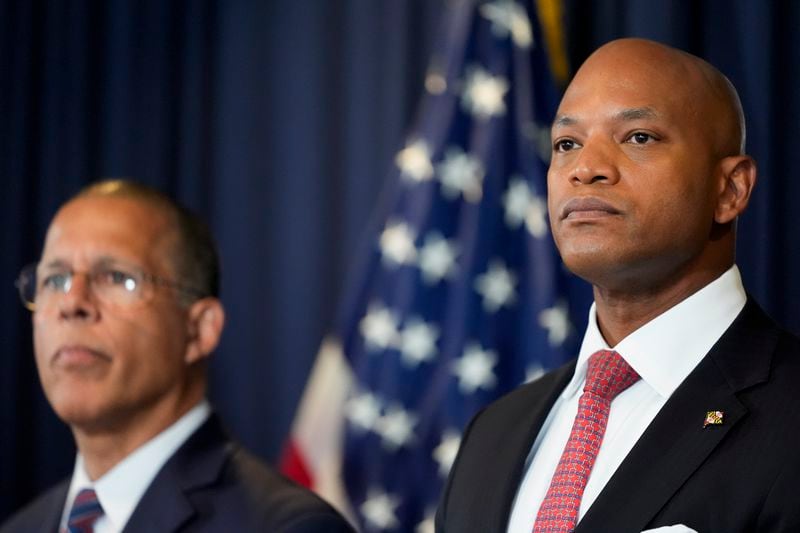 Maryland Gov. Wes Moore, right, flanked by Attorney General Anthony Brown, listens to a question during a press conference announcing a lawsuit seeking damages from the owners and managers of the Dali cargo ship that crashed into the Francis Key Scott Bridge, Tuesday, Sept. 24, 2024, in Baltimore. (AP Photo/Stephanie Scarbrough)