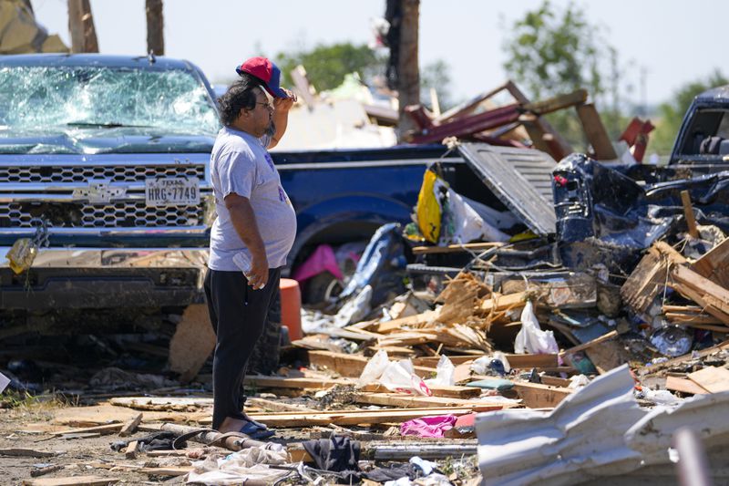 A man looks over debris at an area where people reportedly died during a deadly tornado as it rolled through, Sunday, May 26, 2024, in Valley View, Texas. Powerful storms left a wide trail of destruction Sunday across Texas, Oklahoma and Arkansas after obliterating homes and destroying a truck stop where drivers took shelter during the latest deadly weather to strike the central U.S. (AP Photo/Julio Cortez)