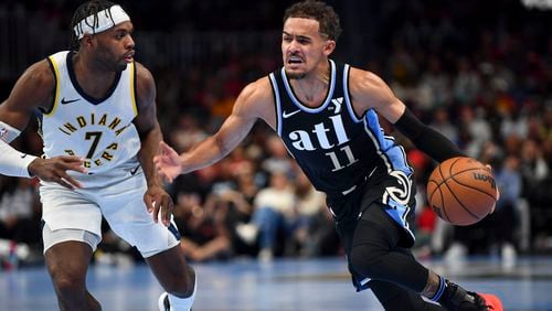 Atlanta Hawks guard Trae Young (11) dribbles to the basket under pressure from Indiana Pacers guard Buddy Hield (7) during the second half of an NBA game Tuesday, November 21, 2023. (Daniel Varnado/For the AJC)