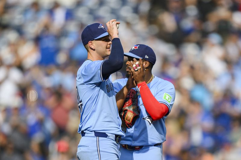 Toronto Blue Jays first baseman Vladimir Guerrero Jr., right, congratulates pitcher Bowden Francis, left, after Francis nearly pitched a no-hitter against the Los Angeles Angels during ninth-inning baseball game action in Toronto, Saturday, Aug. 24, 2024. (Christopher Katsarov/The Canadian Press via AP)