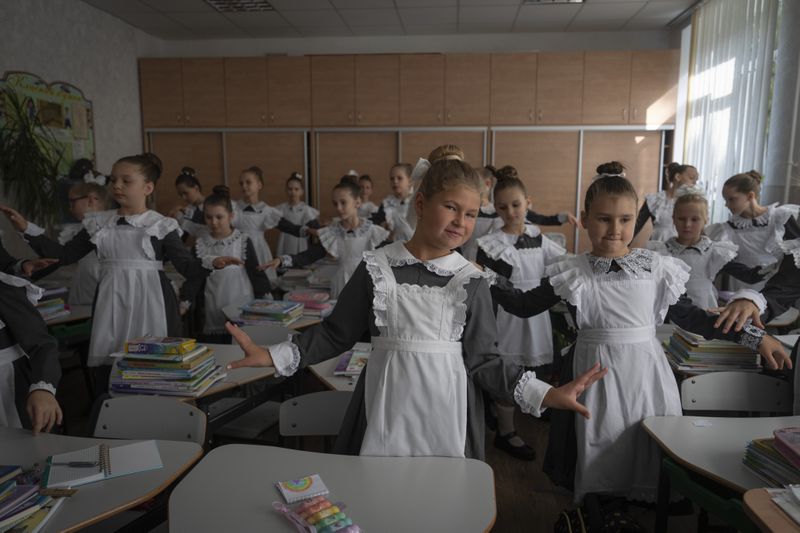 Schoolgirls attend the first lesson in a cadet lyceum on the first day at school in Kyiv, Ukraine, Monday, Sept. 2, 2024. Children and students went to school despite the fact that Kyiv was hit by massive Russian missile barrage early in the morning, causing fires, damaged buildings and infrastructure objects. (AP Photo/Efrem Lukatsky)