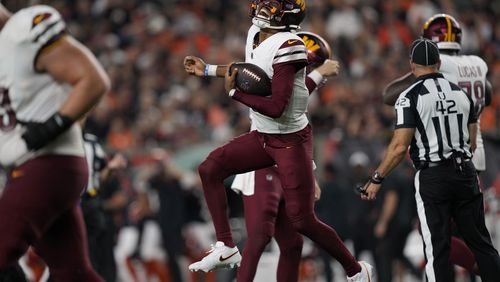 Washington Commanders quarterback Jayden Daniels celebrates after throwing a touchdown pass during the second half of an NFL football game against the Cincinnati Bengals, Monday, Sept. 23, 2024, in Cincinnati. (AP Photo/Carolyn Kaster)