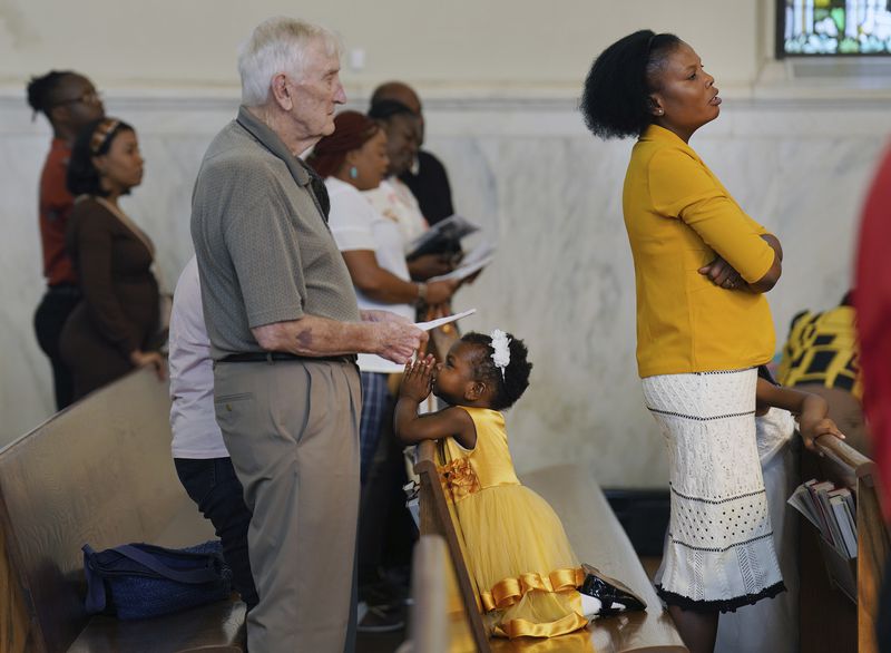 Phara Pierre, right, and her daughter attend Mass at St Raphael Catholic church in Springfield, Ohio, Sunday, Sept. 15, 2024. (AP Photo/Jessie Wardarski)