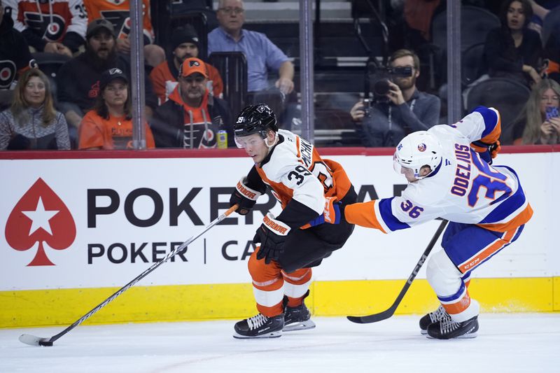 Philadelphia Flyers' Matvei Michkov, left, gets past New York Islanders' Calle Odelius during the second period of a preseason NHL hockey game, Thursday, Sept. 26, 2024, in Philadelphia. (AP Photo/Matt Slocum)