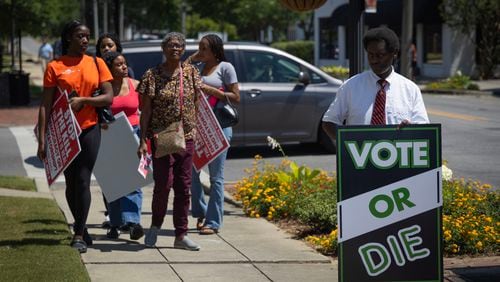 Carrying signs encouraging people to vote, attendees arrive at the Shelby Summit in Columbiana, Ala., on June 21, 2024. The event is an annual commemoration of Shelby County v. Holder, a 2013 Supreme Court case that found a section of the Voting Rights Act of 1965 to be unconstitutional. (Photo by Jordan Moore/News21)