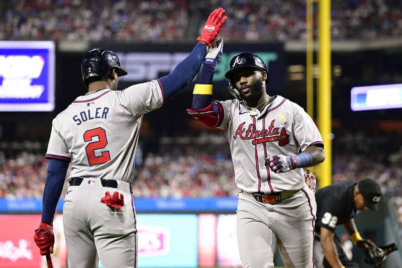 Atlanta Braves' Michael Harris II, right, high-fives Jorge Soler (2) after hitting a solo home run off Philadelphia Phillies' Aaron Nola during the third inning of a baseball game, Sunday, Sept. 1, 2024, in Philadelphia. (AP Photo/Derik Hamilton)