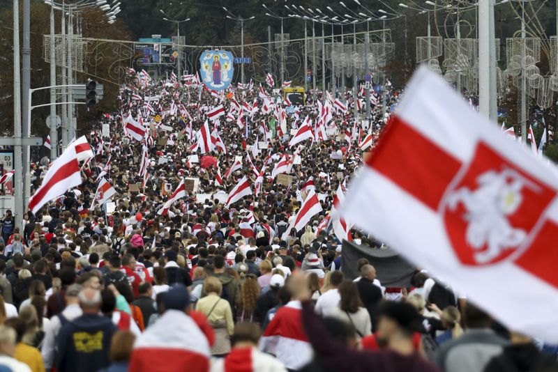 FILE - Protesters with old Belarusian national flags march at an opposition rally in Minsk, Belarus, on Sept. 6, 2020. (AP Photo, File)