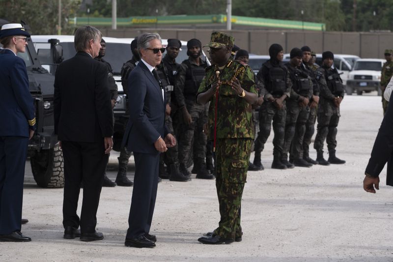 U.S. Secretary of State Antony Blinken, in sunglasses, speaks with Commander of the Multinational Security Support Mission Commander Godfrey Otunge in Port-au-Prince, Haiti, Thursday, Sept. 5, 2024. (Roberto Schmidt/Pool photo via AP)