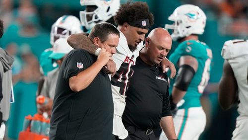 Atlanta Falcons linebacker Bralen Trice (48) is assisted off the field during the first half of a pre season NFL football game against the Miami Dolphins, Friday, Aug. 9, 2024, in Miami Gardens, Fla. (AP Photo/Lynne Sladky)