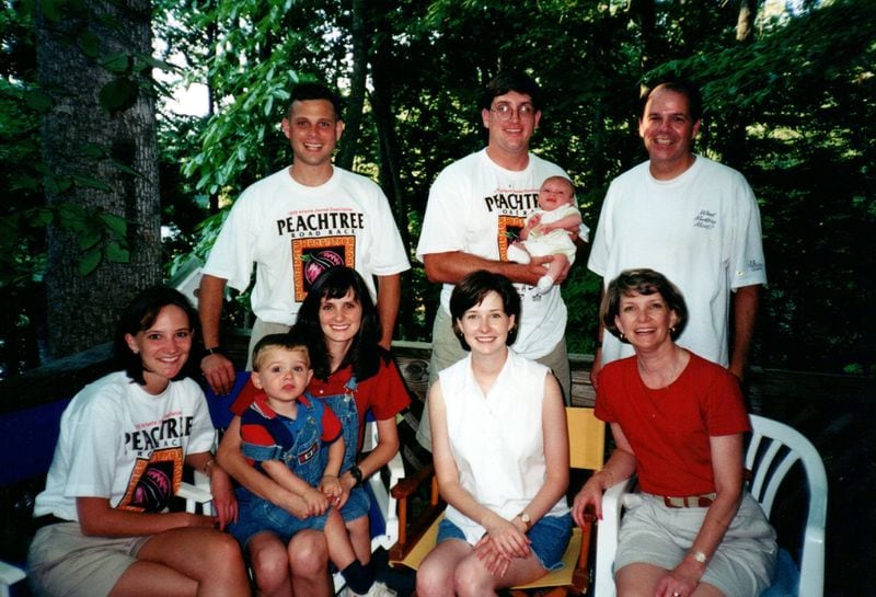 Lance Brady (top right, far right) with his wife, Genie (front row, far right), and daughters Meredith, Drew and Colin (front row, left to right), along with other family members soon after the 1999 AJC Peachtree Road Race. (Photo contributed by Brady family)