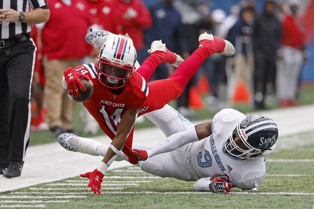 Sandy Creek wide receiver Dalen Penson (14) dives for extra yards as he is tackled by Cedar Grove linebacker Adonijah Green (9) during the first half in the GHSA Class 3A finals, at Center Parc Stadium, Saturday, December 10, 2022, in Atlanta. (Jason Getz / Jason.Getz@ajc.com)