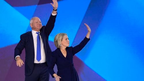 Democratic vice presidential nominee Minnesota Gov. Tim Walz, left, and his wife Gwen Walz wave to the crowd on stage during the Democratic National Convention Wednesday, Aug. 21, 2024, in Chicago. (AP Photo/J. Scott Applewhite)