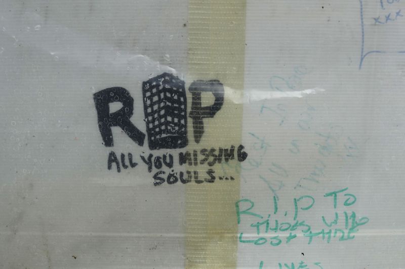 FILE - A view of tribute messages for the 72 people who died in the Grenfell Tower fire, are seen on display almost a year later, on a tribute wall near the tower in London, Wednesday, May 30, 2018. (AP Photo/Matt Dunham, File)