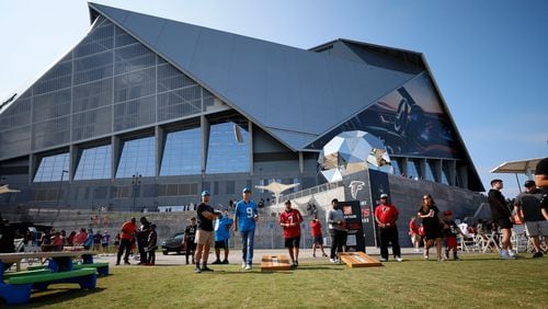 Panthers fan Benjamin Willis and Falcons fan Steven Lance (center) are seen playing corn hole by the Home Depot backyard before the Falcons season opener against the Carolina Panthers on Sunday, Sept. 10, 2023, in Atlanta.
Miguel Martinz/miguel.martinezjimenez@ajc.com