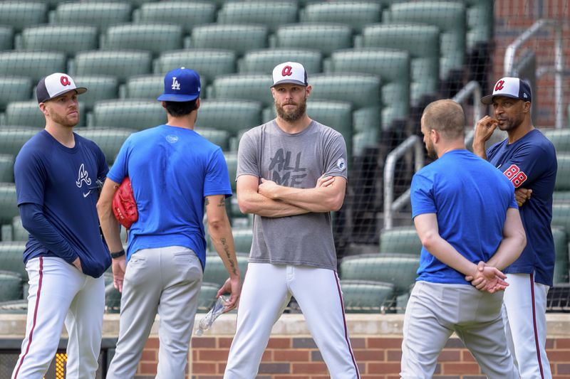 Atlanta Braves pitcher Chris Sale, center, pitcher Aaron Bummer, left, and first base coach Tom Goodwin, right, talk with players from the Los Angeles Dodgers prior to a baseball game, Monday, Sept. 16, 2024, in Atlanta. (AP Photo/Jason Allen)