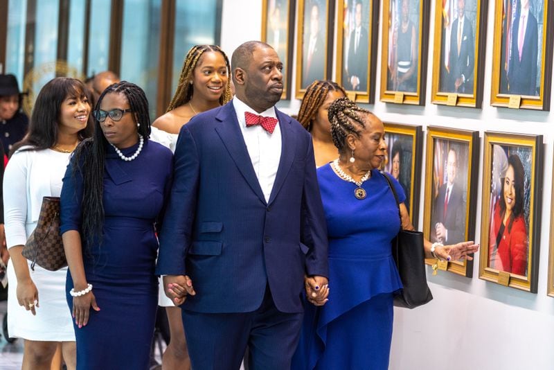 Marvin Arrington Jr. (center) and family walk past photos of current city council members at Atlanta City Hall before celebrating the life of Marvin Arrington Sr. on Thursday, July 27, 2023. Marvin Arrington Sr., former superior court judge and Atlanta City Council president, lay in state at city hall. (Arvin Temkar / arvin.temkar@ajc.com)