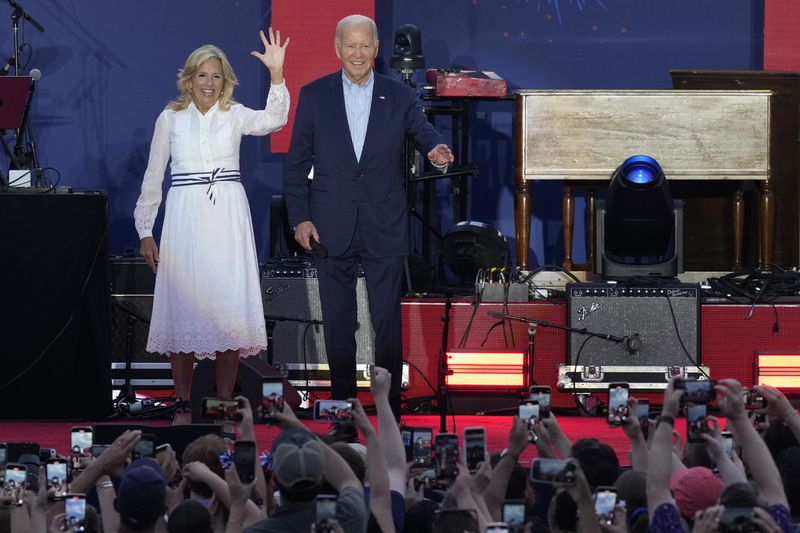 President Joe Biden and first lady Jill Biden arrive on stage to speak to active-duty military service members and their families during a Fourth of July celebration and barbecue on the South Lawn of the White House in Washington, Thursday, July 4, 2024. (AP Photo/Susan Walsh)