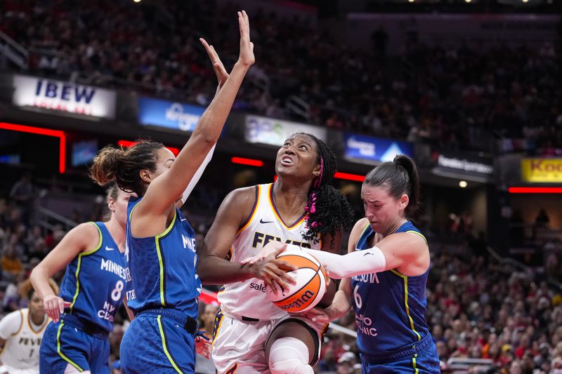 Indiana Fever forward Aliyah Boston (7) is fouled as she shoots between Minnesota Lynx forward Napheesa Collier, left, and forward Bridget Carleton (6) in the second half of a WNBA basketball game in Indianapolis, Friday, Sept. 6, 2024. (AP Photo/Michael Conroy)