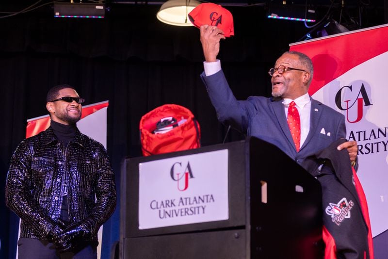 Clark Atlanta President George French, Jr., presents Usher with a hat during a homecoming rally for Usher at Clark Atlanta University in Atlanta on Wednesday, February 14, 2024. Along with other honors, Amazon presented a $25,000 donation to Usher’s New Look Foundation. (Arvin Temkar / arvin.temkar@ajc.com)