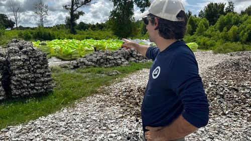 Michael Boris, with the Coalition to Restore Coastal Louisiana (CRCL), shows off thousands of Oyster shells that will eventually be used to fight coastal erosion along the southern most parts of the state, Wednesday, July 24, 2024, in Violet, La. (AP Photo/Stephen Smith)
