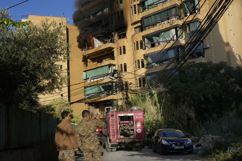 Lebanese soldiers stand in front of an apartment which caught fire after an Israeli airstrike in Dahieh, Beirut, Lebanon, Wednesday, Oct. 2, 2024. (AP Photo/Hussein Malla)