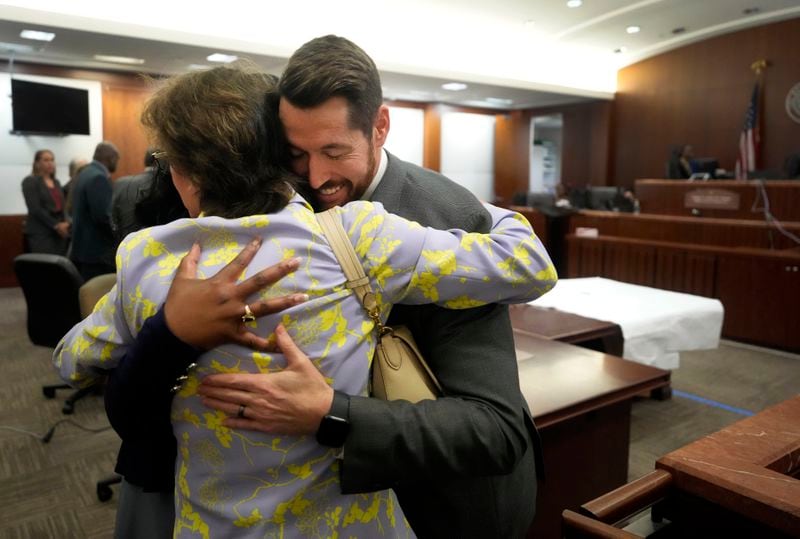 Harris County District Attorney Kim Ogg, center, hugs prosecutors Tanisha Manning, left, and Keaton Forcht, right, as they wait for the jury to enter the courtroom for the verdict in the murder trial of former Houston police officer Gerald Goines in the 482nd District Court at the Harris County Criminal courthouse Wednesday, Sept. 25, 2024, in Houston. (Melissa Phillip/Houston Chronicle via AP, Pool)