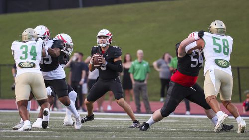 Milton quarterback Luke Nickel (5) looks to pass with protection from Milton offensive lineman during the first half against Buford at Milton High School, Friday, August 16, 2024, in Milton, Ga. (Jason Getz / AJC)
