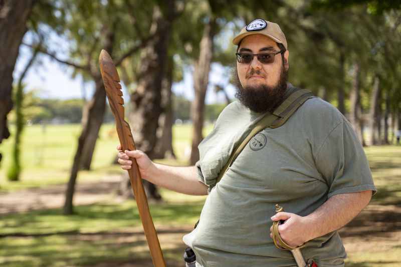 Michael Rice holds a Hawaiian war spear, Ihe, which his uncle made with koa wood 20 years ago, at Kapiolani Park on Saturday, June 22, 2024, in Honolulu, Hawaii. (AP Photo/Mengshin Lin)