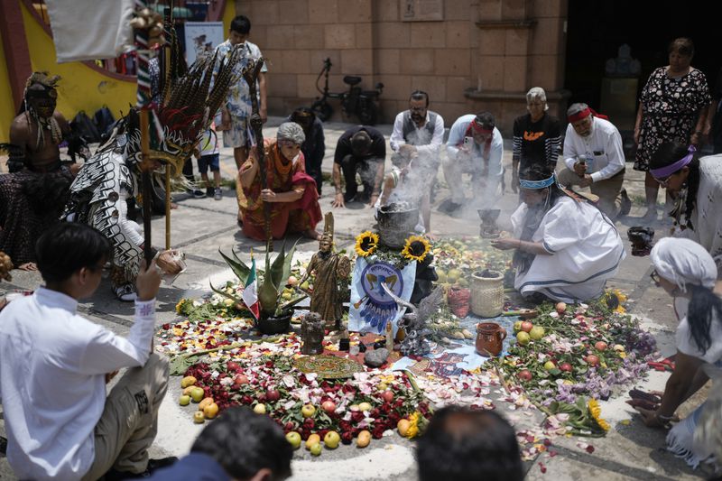 Residents and members of an Amaxac Indigenous organization participate in a ceremony commemorating the 503rd anniversary of the fall of the Aztec empire's capital, Tenochtitlan, in Mexico City, Tuesday, Aug. 13, 2024. (AP Photo/Eduardo Verdugo)