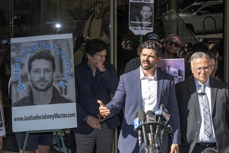 Actor Micah Parker "Vampire Diaries," organizer of Justice for Johnny Wactor, at the podium, speaks at a news conference outside the Clara Shortridge Foltz Criminal Justice Center in Los Angeles, Monday, Aug. 19, 2024. Standing, Los Angeles City Council member Kevin de Leon, rear left, and detective Moses Castillo, front right. (AP Photo/Damian Dovarganes)